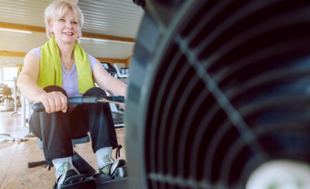 Smiling, older woman exercising on a rower