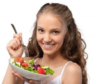 lose holiday weight - pretty, smiling young woman eating a salad