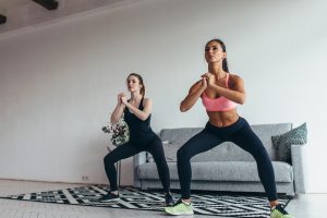 Two women doing a Squat workout at home