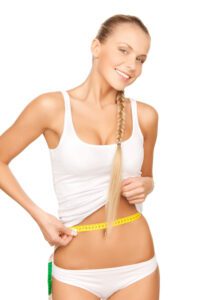 Smiling blonde woman measuring her waist