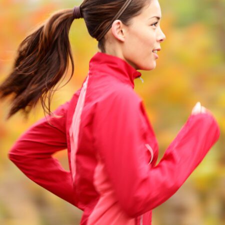 Prodile of young Eurasian woman jogging in the fall.