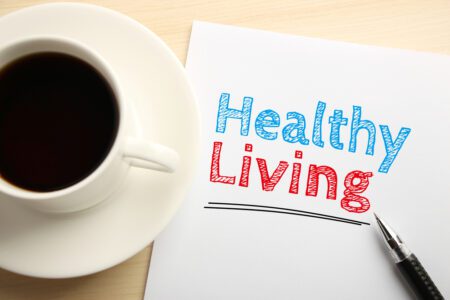 Cup of black coffee next to a healthy living sign